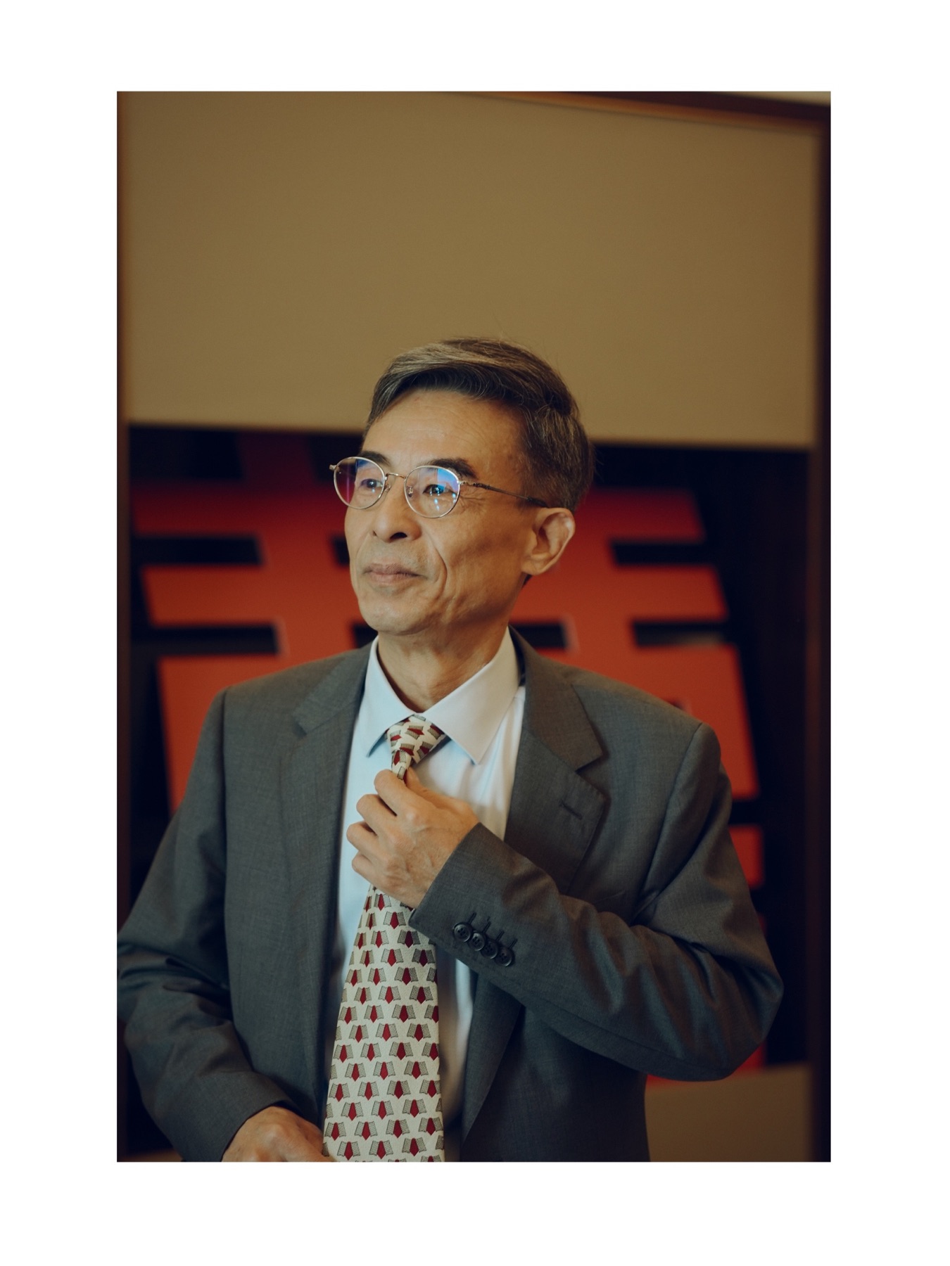 父亲站在红色喜字前整理领带