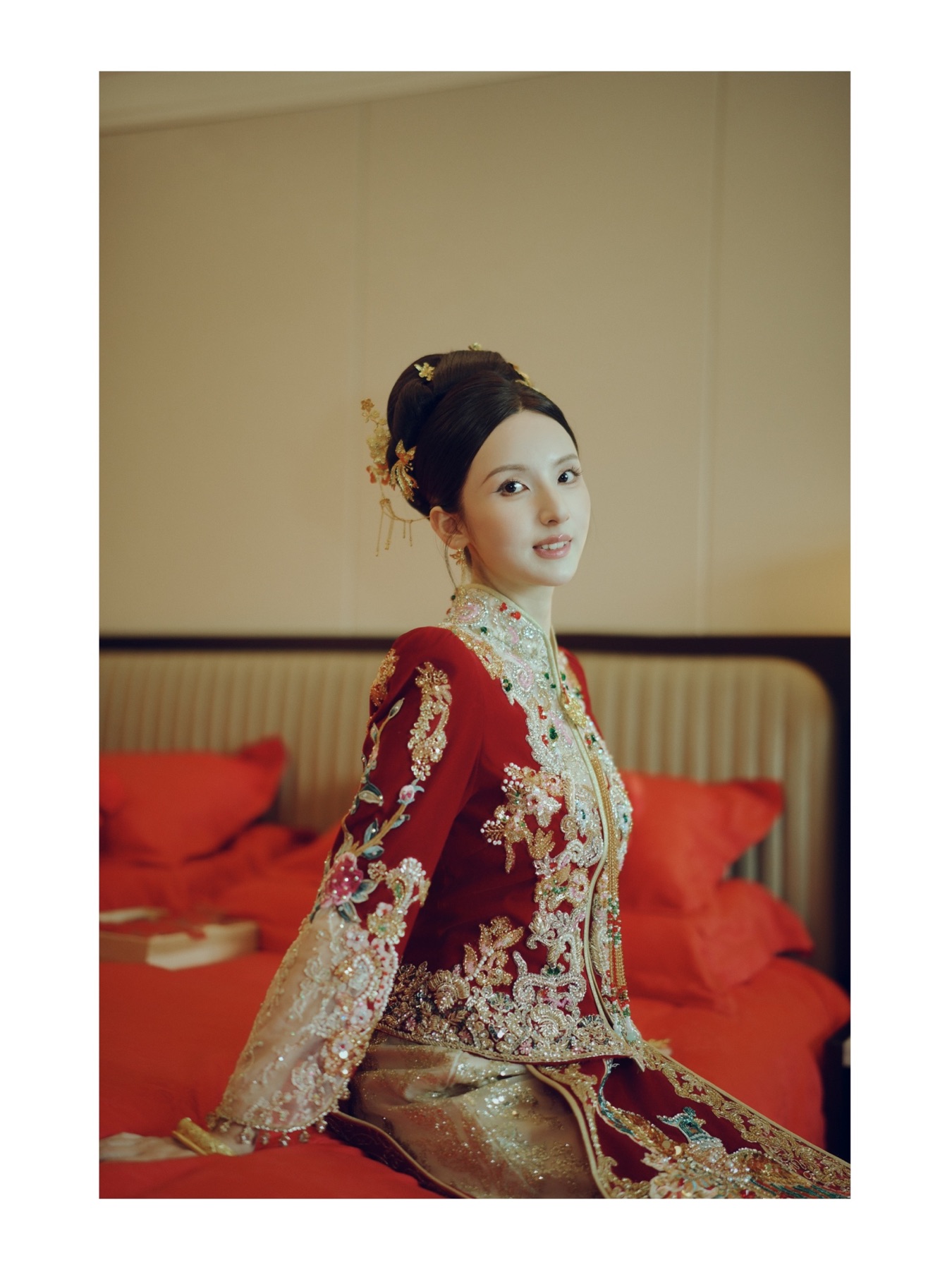 新娘穿着红色中式礼服坐在婚床边