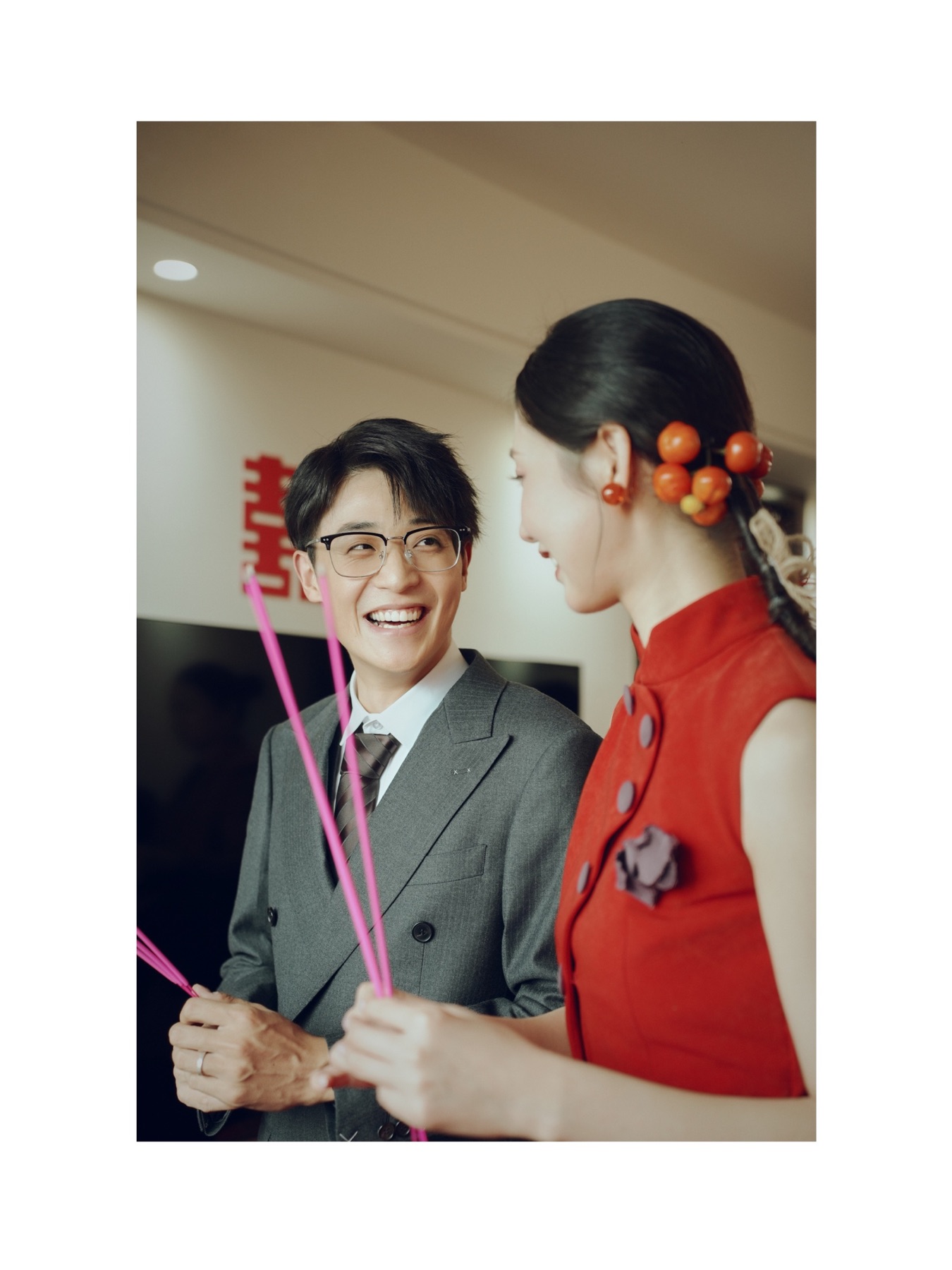 新人拿着彩色游戏道具，在婚房里相视微笑